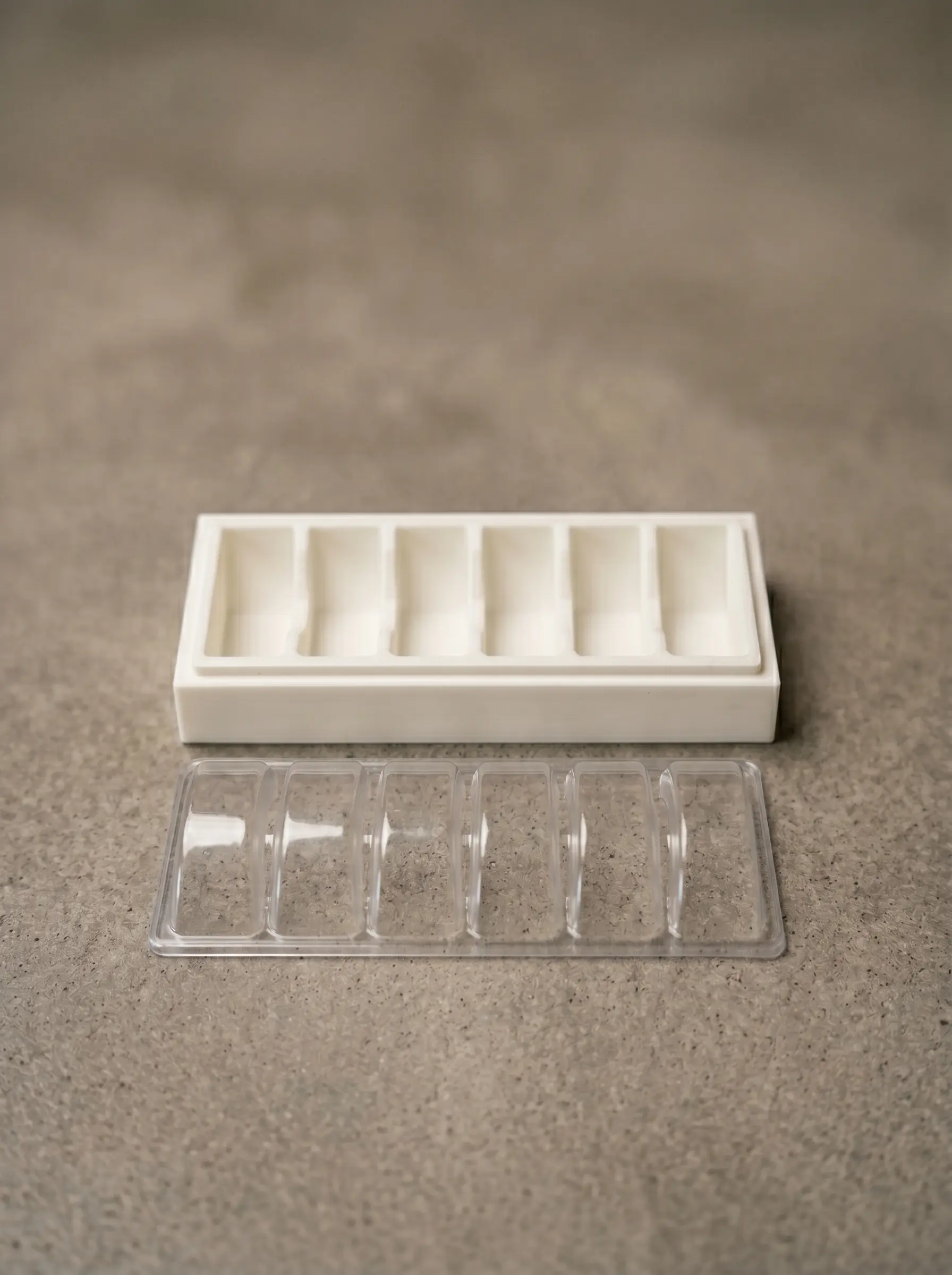Vacuum-form positive plug printed in PLA, paired with the resulting clear thermoformed 6-cavity blister tray